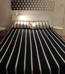 Casetta di Myra في باري: سرير بخطوط سوداء وبيضاء في الغرفة