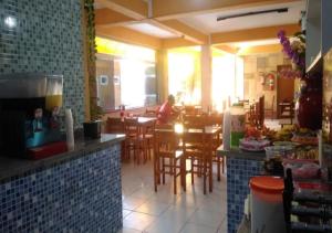 a person sitting at a table in a restaurant at Hotel Alaska in Peruíbe