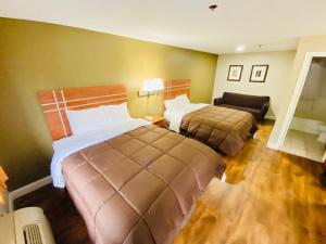 Habitación de hotel con 2 camas y sofá en Rodeway Inn en Swansea