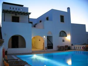 a villa with a swimming pool in front of a house at Aegeon Hotel in Naxos Chora
