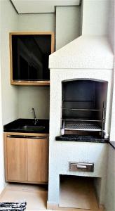 een keuken met een oven en een wastafel bij Apartamento 2 Novíssimo e Bem Localizado - Itaguá - UBATUBA-SP in Ubatuba