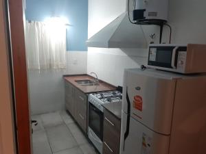 een kleine keuken met een magnetron bovenop een koelkast bij Casa Elisa in Ciudad Lujan de Cuyo