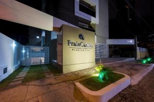 a building with a sign on the side of it at night at Premium Flat Praia Calma in Natal