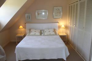 a bedroom with a white bed with two lamps at Résidence Clairbois, Chambres d'Hôtes in Fère-en-Tardenois