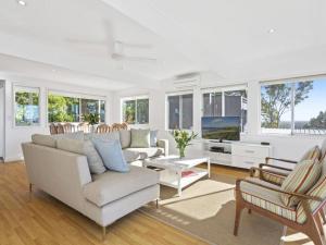 a living room with a couch and a tv at Noosa Escape 2Br Allambi Rise in Noosa Heads