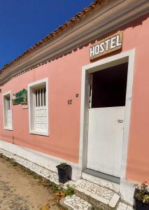 różowy dom z białymi drzwiami w obiekcie Hostel Casa Grande w mieście Prado