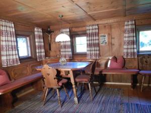 a dining room with a table and chairs and windows at Ferienhaus Vollspora in Tschagguns