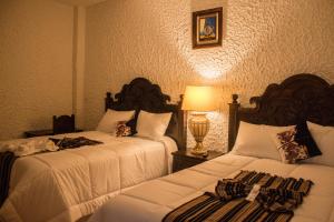 A bed or beds in a room at Hotel Taa' Tiin
