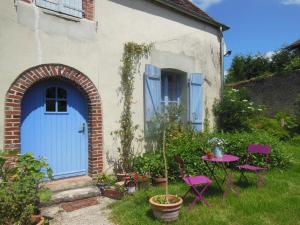 a house with a blue door and a table and chairs at Chambres d'Hôtes des Grands Prés in Argentan