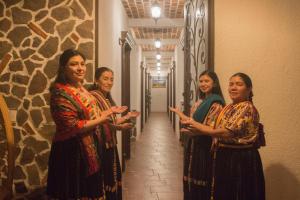 a group of women standing in a hallway talking at Hotel Taa' Tiin in San Juan La Laguna