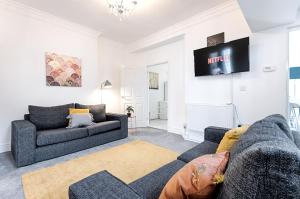 a living room with two couches and a tv at Make this your base! TV in every bedroom! in Merthyr Tydfil