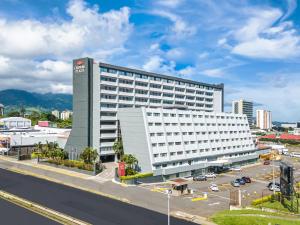 a large white building in a city with a parking lot at Crowne Plaza San Jose La Sabana, an IHG Hotel in San José