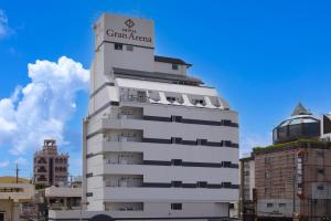 un edificio blanco con un cartel encima en HOTEL Gran Arenaホテルグランアリーナ en Okinawa City