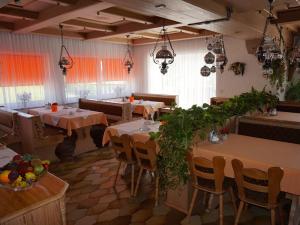 a restaurant with tables and chairs in a room at Pension zur Klause in Bodenmais