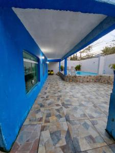 Casa azul con suelo de piedra y pared azul en Casa Praia do Pernambuco, en Guarujá