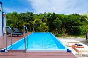 a blue swimming pool on a deck with a bench at Regina Ishigaki in Ishigaki Island
