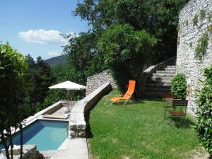 a garden with a swimming pool and a chair and an umbrella at Casa Luce Labro in Labro