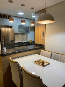a kitchen with a white table and chairs in a room at Apartamento em Gramado com piscina in Gramado