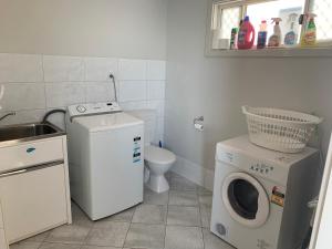 lavadero con lavadora y fregadero en Beachside & Jetty View Apartment 7 - Sea Eagle Nest Apartment, en Streaky Bay