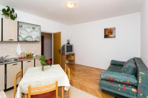 a kitchen and living room with a table and a couch at Apartmani Kate, Plat in Mlini +16 photos