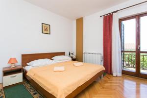a bedroom with a bed and a large window at Apartmani Kate, Plat in Mlini