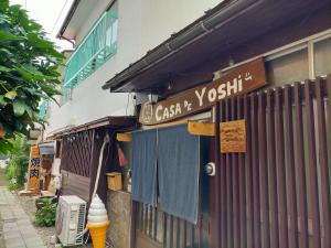 un panneau indiquant un restaurant de sushis sur le côté d'un bâtiment dans l'établissement CASA DE YOSHi 一棟貸し, à Yamagata