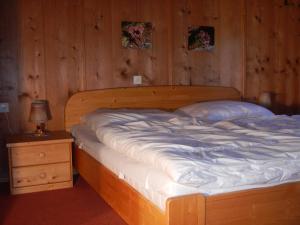 Bett in einem Zimmer mit einer Holzwand in der Unterkunft Ferienhaus Vollspora in Schruns-Tschagguns