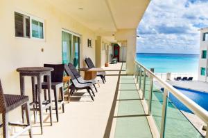 a balcony with chairs and a view of the ocean at Departamento sobre la playa Cancun in Cancún