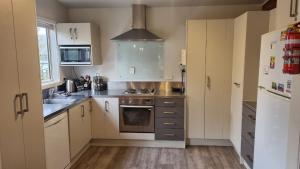 Una cocina con gabinetes blancos y un horno de estufa. en 9 Leamington Street, en Hanmer Springs