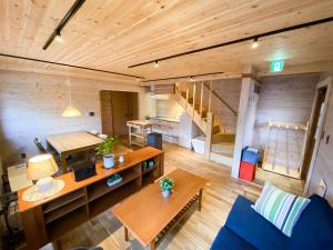 a living room with wooden walls and a staircase at BAAN HAKUBA in Hakuba