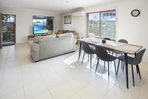 a living room with a table and chairs at Paynesville Villa in Paynesville