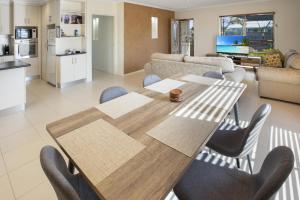 a kitchen and living room with a wooden table and chairs at Paynesville Villa in Paynesville