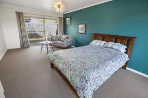 a bedroom with a bed with a blue wall at Paynesville Villa in Paynesville