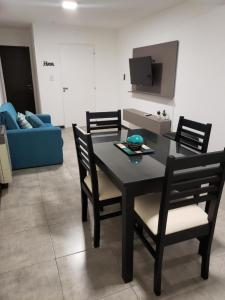 mesa de comedor con sillas y sofá azul en Costanera.VM en Villa María
