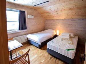 een slaapkamer met 2 bedden in een blokhut bij BAAN HAKUBA in Hakuba