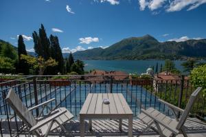 uma mesa e cadeiras numa varanda com vista para um lago em Albergo Silvio em Bellagio