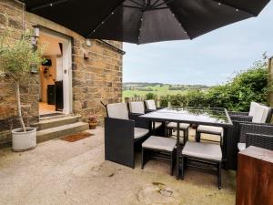 a table and chairs with an umbrella on a patio at The Thyme House in Keighley