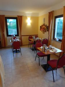 a dining room with tables and red chairs at Hotel Prox in Arnstadt