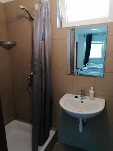 ein Bad mit einem Duschvorhang und einem Waschbecken in der Unterkunft Omega Szigetszentmiklós in Szigetszentmiklós