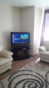 a living room with a flat screen tv and a couch at герасимова 12 in Narva