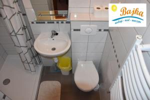 La petite salle de bains est pourvue d'un lavabo et de toilettes. dans l'établissement Noclegi-Bajka, à Ustronie Morskie