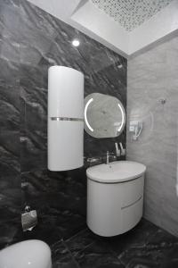 a bathroom with a white sink and a mirror at Reikartz Amirun Tashkent in Tashkent