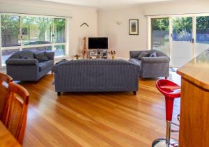 a living room with two couches and a tv at Lochnagar Barossa in Tanunda