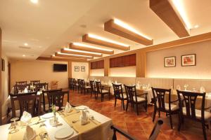a restaurant with tables and chairs in a room at Hotel Crystal Plaza in Ernakulam