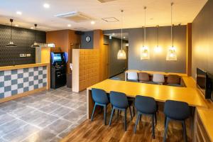 un restaurante con mesa y sillas en una habitación en R9 Hostel Tochigi Ekimae en Tochigi