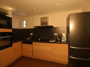 eine Küche mit einem Kühlschrank aus Edelstahl und Holzschränken in der Unterkunft Appartement Valloire, 4 pièces, 8 personnes - FR-1-263-214 in Valloire