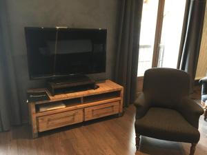 een woonkamer met een televisie en een stoel bij Appartement Valloire, 4 pièces, 8 personnes - FR-1-263-214 in Valloire