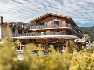 un gran edificio de madera con un balcón en la parte superior. en Appartement La Clusaz, 4 pièces, 6 personnes - FR-1-304-241, en La Clusaz