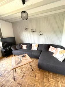 - un salon avec un canapé noir et une table dans l'établissement Ferienhaus Sonnendeck 2, à Simmerath