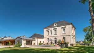a large white house on a grass field at Appartement du Château de la Caillerie in Avoine